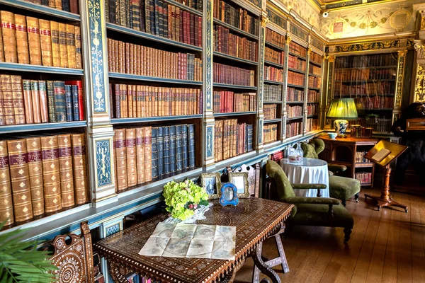 A heritage library bookcase packed wall-to-wall with leather-bound books